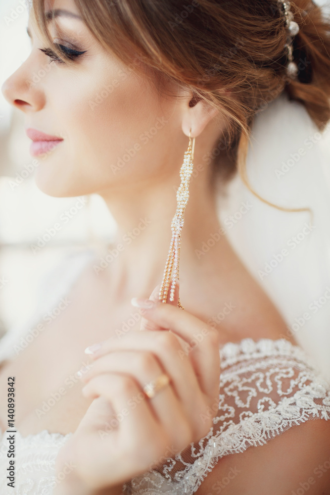 Profile of stunning dark blonde bride with long golden earrings