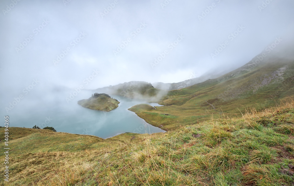 alpine lake in dence fog