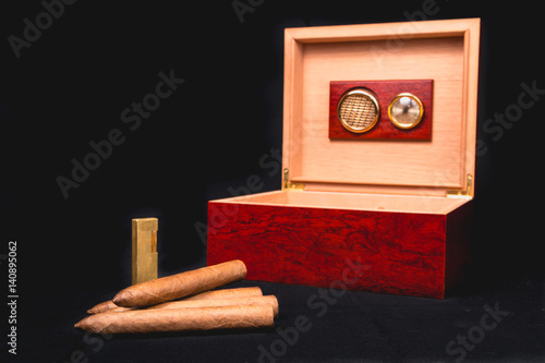 Fotografija Cigar box on black background and lighter