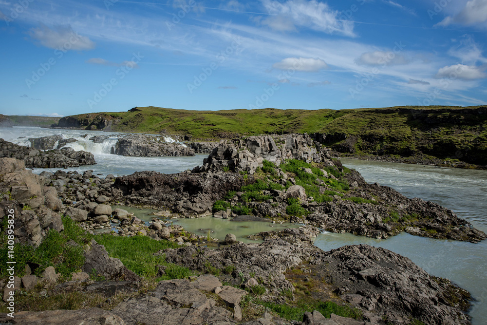 Green valley with river and waterfall. Icelandic landscape.