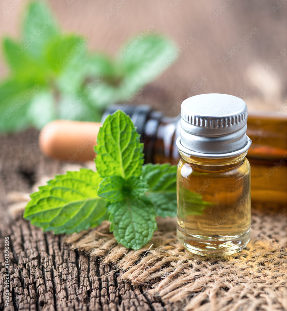 fresh mint essential oil on wood background fresh mint essential oil on wood background