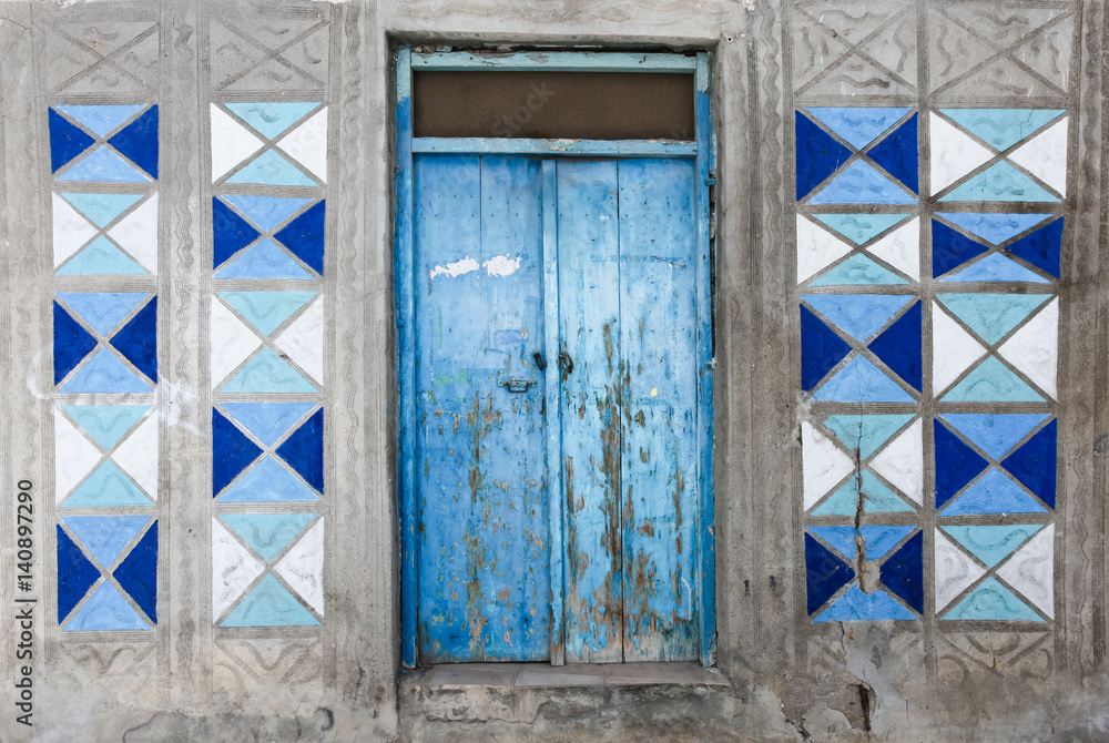 Fototapeta , -Traditional Greek facade of house with blue wooden door and blue and white colored patterns on the gray wall. Rethymno, Island Crete, Greece