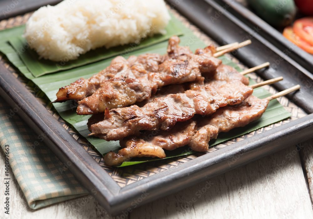 Thai styled grilled pork and sticky rice on wood Thai styled grilled pork and sticky rice on wood