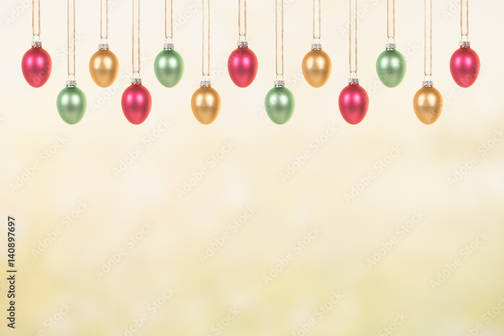 Yellow, green and pink decorative glass easter eggs hanging on a green yellow spring background Yellow, green and pink decorative glass easter eggs hanging on a green yellow spring background
