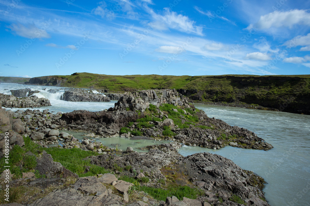 Green valley with river and waterfall. Icelandic landscape.