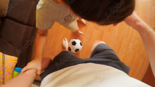 TOP VIEW: Home football - Father plays with a son at home photo