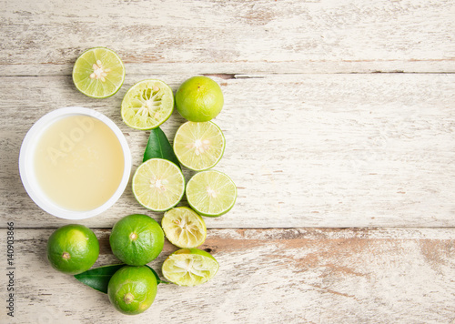 freshly squeezed lime juice with lime fruits on wood table,top view