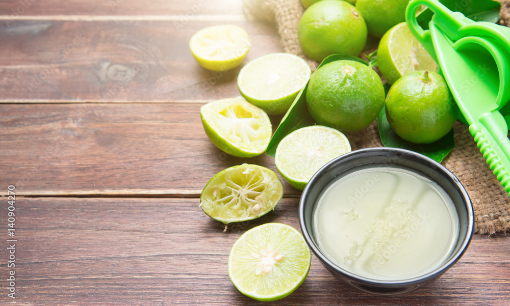 freshly squeezed lime juice with lime fruits on wood table freshly squeezed lime juice with lime fruits on wood table
