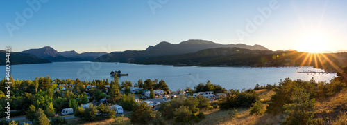 Panoramic view of the lake Lac de Serre Poncon in the French Alps and a campsite with sunset photo