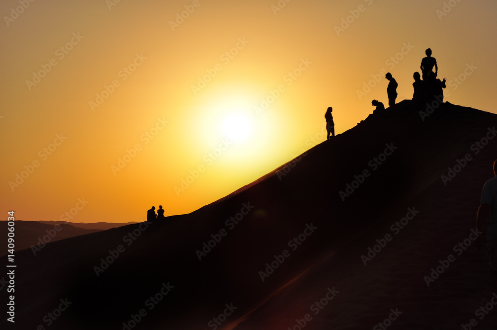 People Silhouetted On A Desert Dune People Silhouetted On A Desert Dune