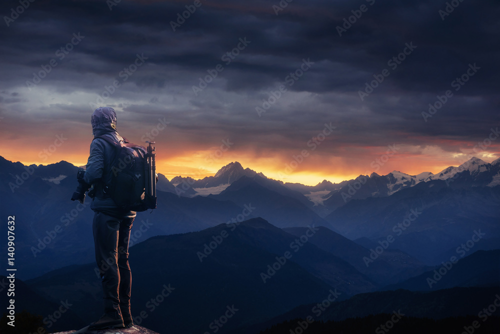 Professional photographer takes photos with big camera on peak of rock Professional photographer takes photos with big camera on peak of rock