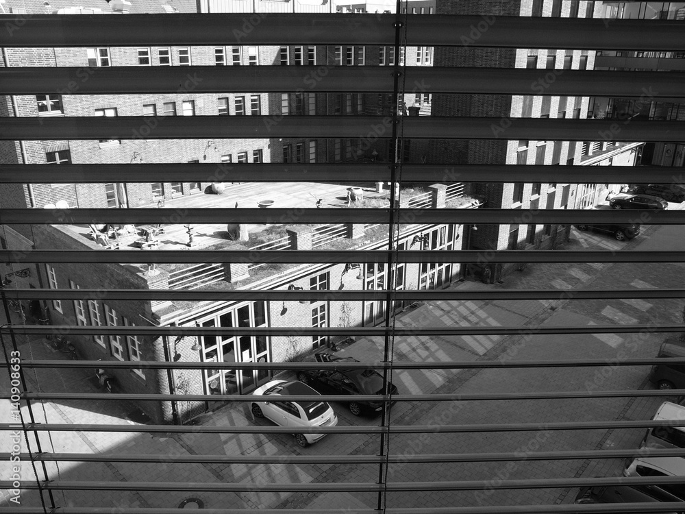 Blick aus dem Hotelzimmer durch Jalousien auf den Innenhof der Feuerwache  im Hansaviertel oder Hafenviertel am Hafen von Münster in Westfalen im  Münsterland, fotografiert in klassischem Schwarzweiß Stock-Foto | Adobe  Stock