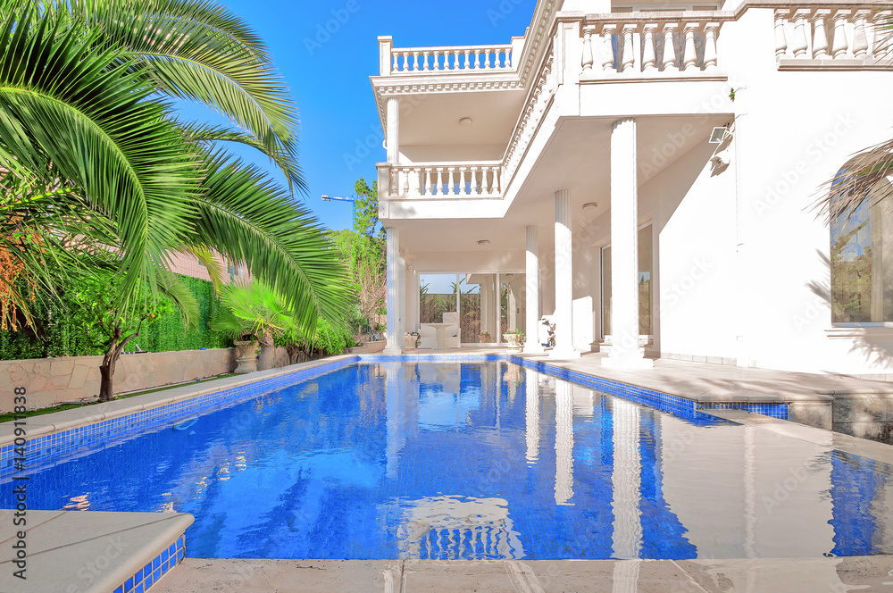 Foto Stock Luxury white house with swimming pool. Luxury villa in classical  style with columns. Backyard with swimming pool in mansion. | Adobe Stock