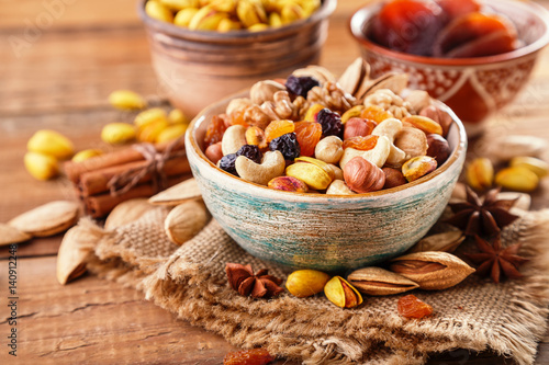 Mix of nuts and dried fruits on a old rustic table. Gold pistachios, cashews, hazelnuts, almonds. Food background.