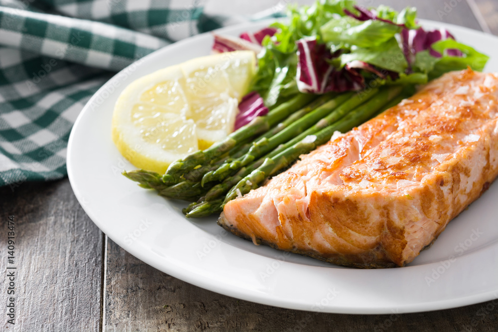Grilled salmon fillet with asparagus and salad in plate on wooden table
Grilled salmon fillet with asparagus and salad in plate on wooden table