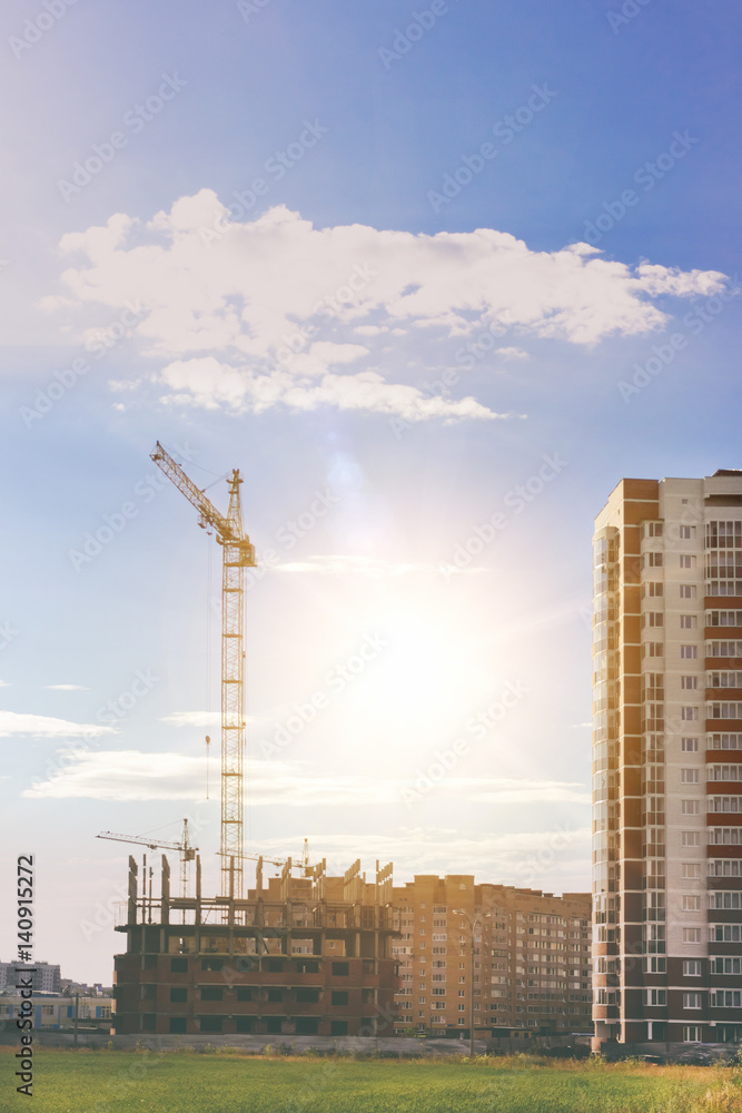 Construction crane and a building house. Sky,clouds,sunlight Construction crane and a building house. Sky,clouds,sunlight