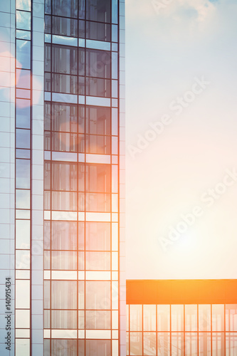 Skyscraper reflection of the glass . Blue sky with sun background