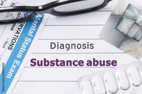 Diagnosis Substance Abuse. Medical notebook labeled Diagnosis Substance Abuse, psychiatric mental questionnaire and pills are on table in psychiatrist cabinet or counselor of this issue or problem