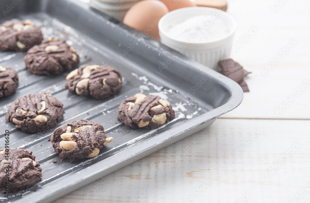Delicious chocolate cookies with nuts on a baking tray