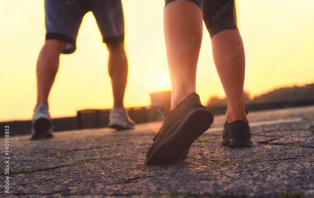 man's legs and a girl in sneakers running at sunset. man's legs and a girl in sneakers running at sunset.