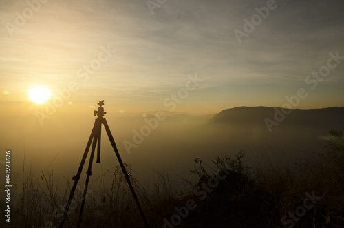 Silhouette of tripod (for DSLR camera) with sunset background in northern of Thailand.