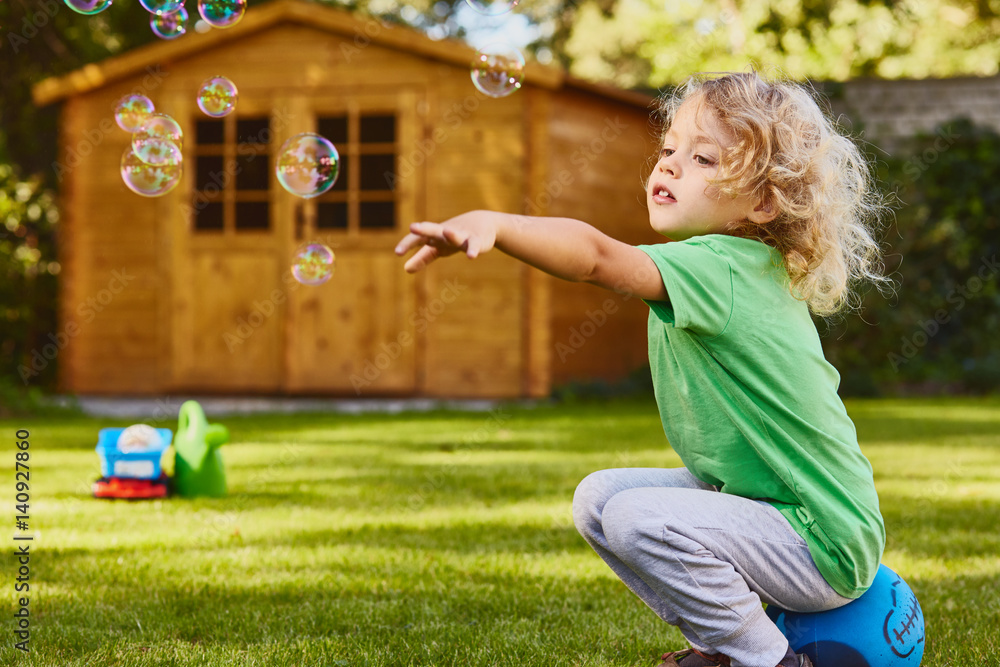 Obraz premium Small boy playing in garden
