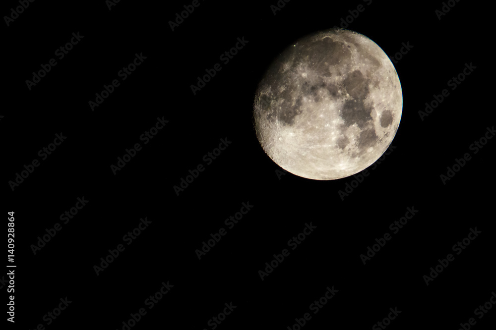 A lightly golden moon with a lot of craters. A lightly golden moon with a lot of craters.