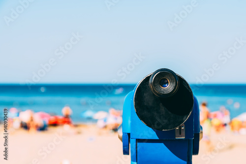 Blue Coin Operated Telescope With Beach And Ocean Background