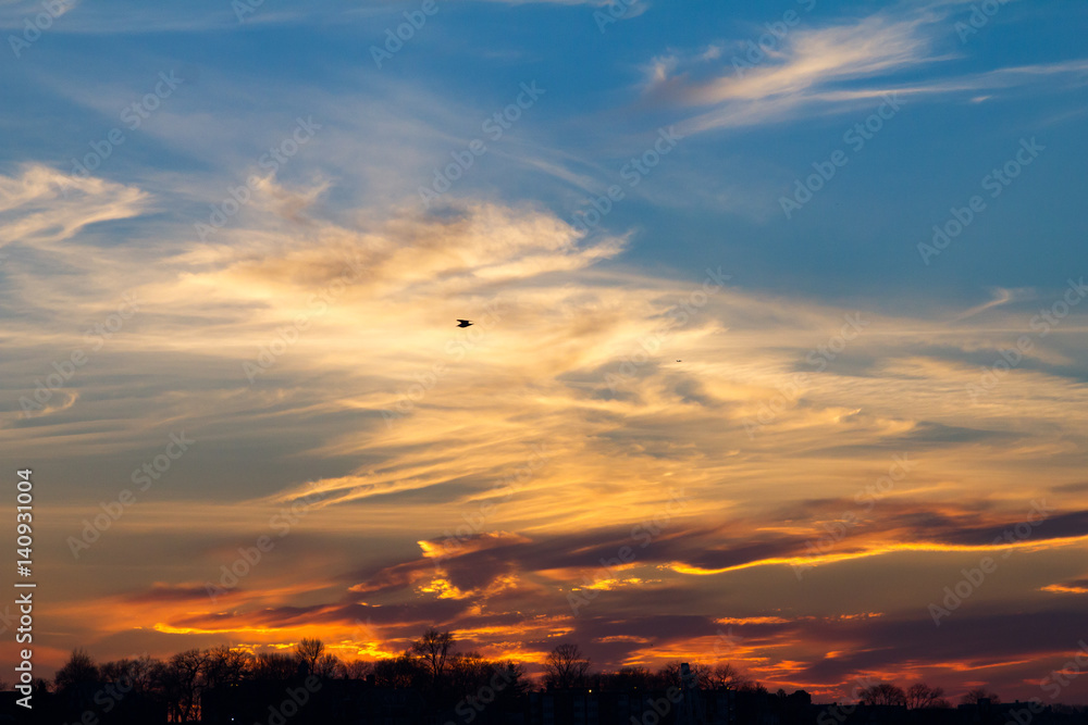 Wisps of clouds in the sky during a colorful sunset background