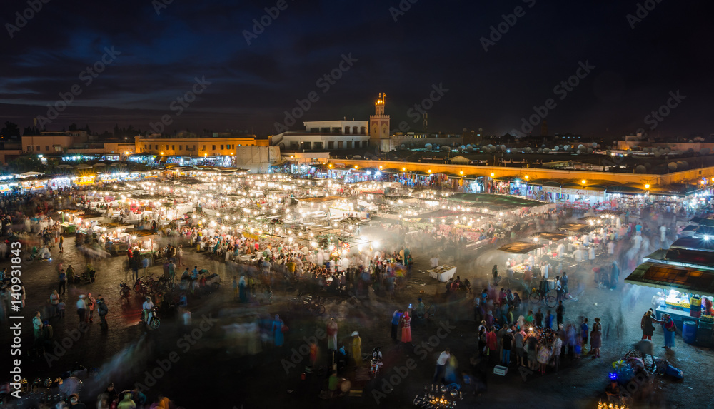 Fototapeta premium Famous square Jemaa El Fna busy with many people and lights during the night, medina of Marrakesh, Morocco