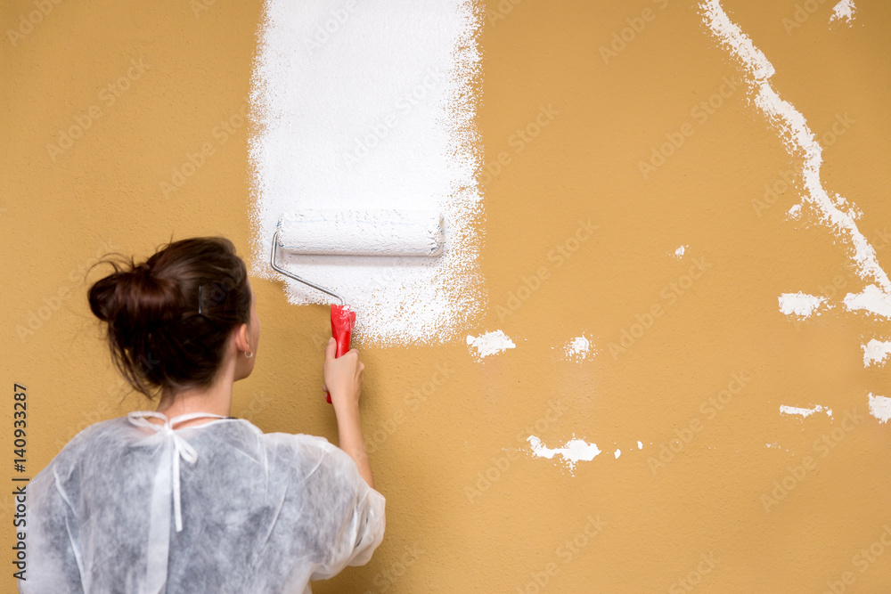 Frau streicht eine braune Wand weiß, Umbau und Renovierung Stock Photo ...