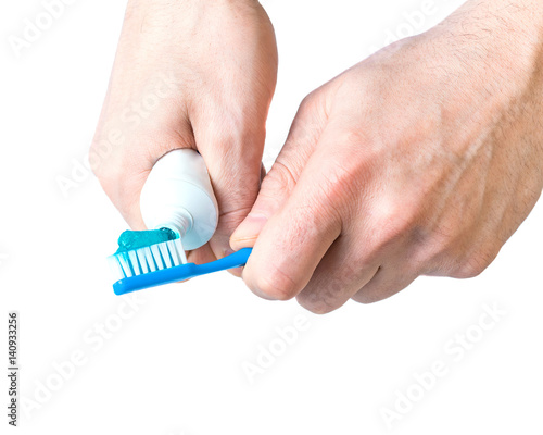 toothbrush with toothpaste applied in hand isolated on white background photo