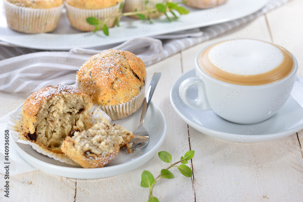 Stracciatella-Bananen-Muffins mit Cappuccino -Freshly baked chocolate banana muffins with a cup of cappuccino