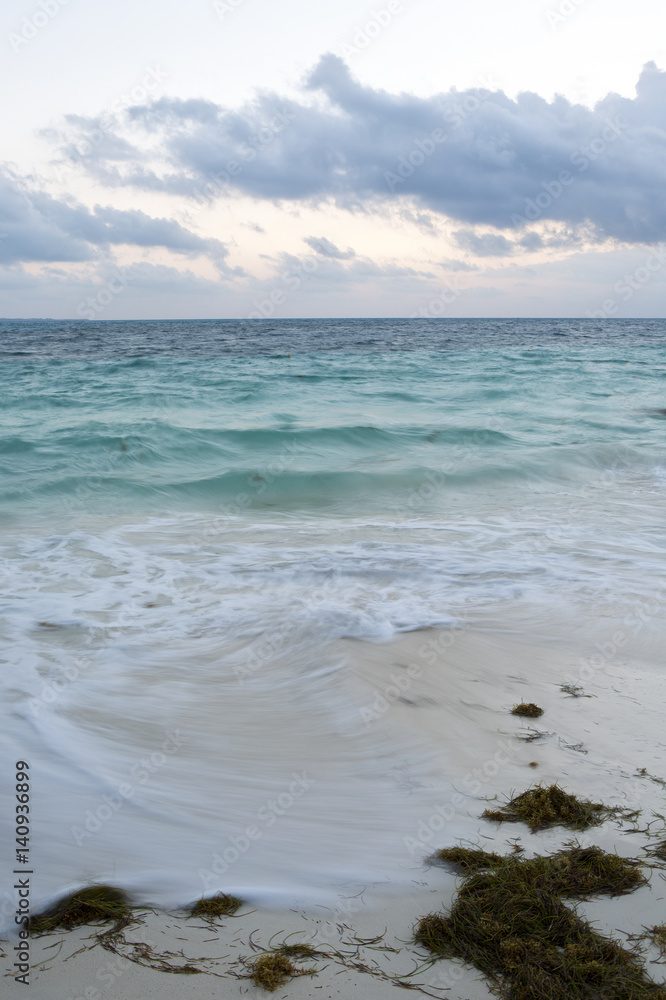 Long exposure waves from the Caribbean sea in the early morning. Vertical image for wallpaper. Dramatic sky. Long exposure waves from the Caribbean sea in the early morning. Vertical image for wallpaper. Dramatic sky.