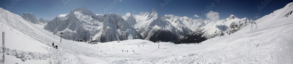Winter panorama of a mountain landscape, snow-capped peaks and slopes.