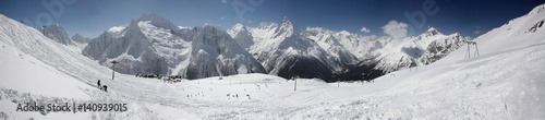 Winter panorama of a mountain landscape, snow-capped peaks and slopes.