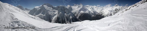 Winter panorama of a mountain landscape, snow-capped peaks and slopes.