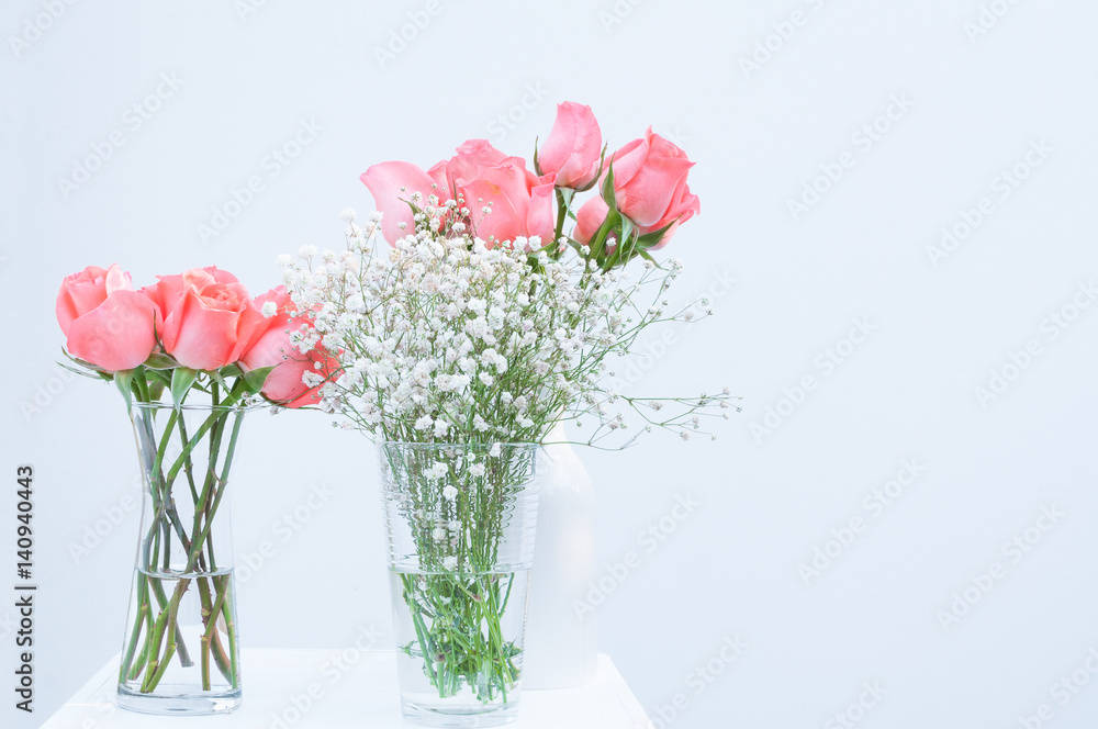 bunch of pink rose eustoma flowers in glass vase on white background