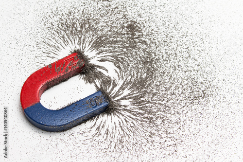 Red and blue horseshoe magnet or physics magnetic with iron powder magnetic field on white background. Scientific experiment in science class in school. photo