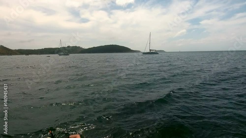 Copter aerial view, fly over the yachts moored in a bay and man swimming with mask photo