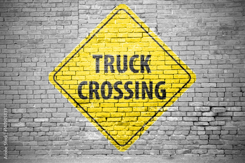 Ziegelsteinmauer mit Verkehrszeichen Truck Crossing Graffiti 