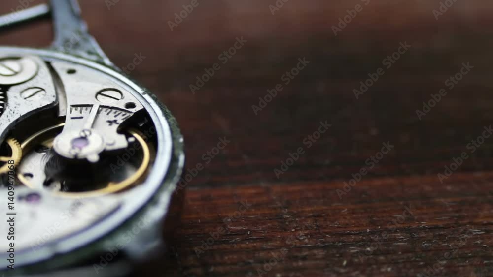 .Inside of watch mechanism On a stylish wooden background .Inside of watch mechanism On a stylish wooden background
