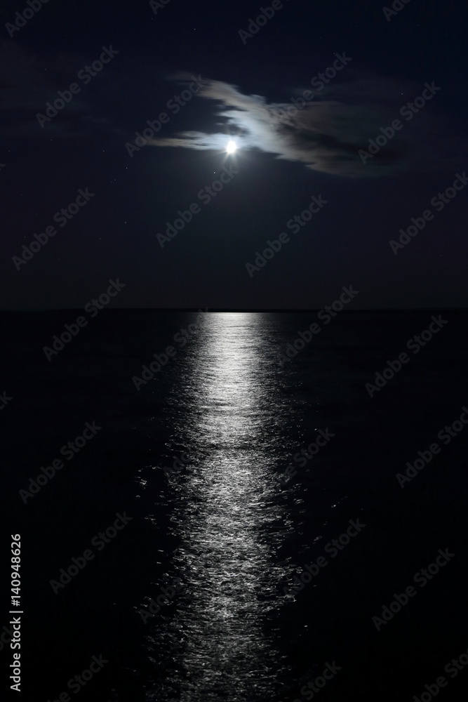 The night sky and the moon path on the river. Stars and a strip of ...