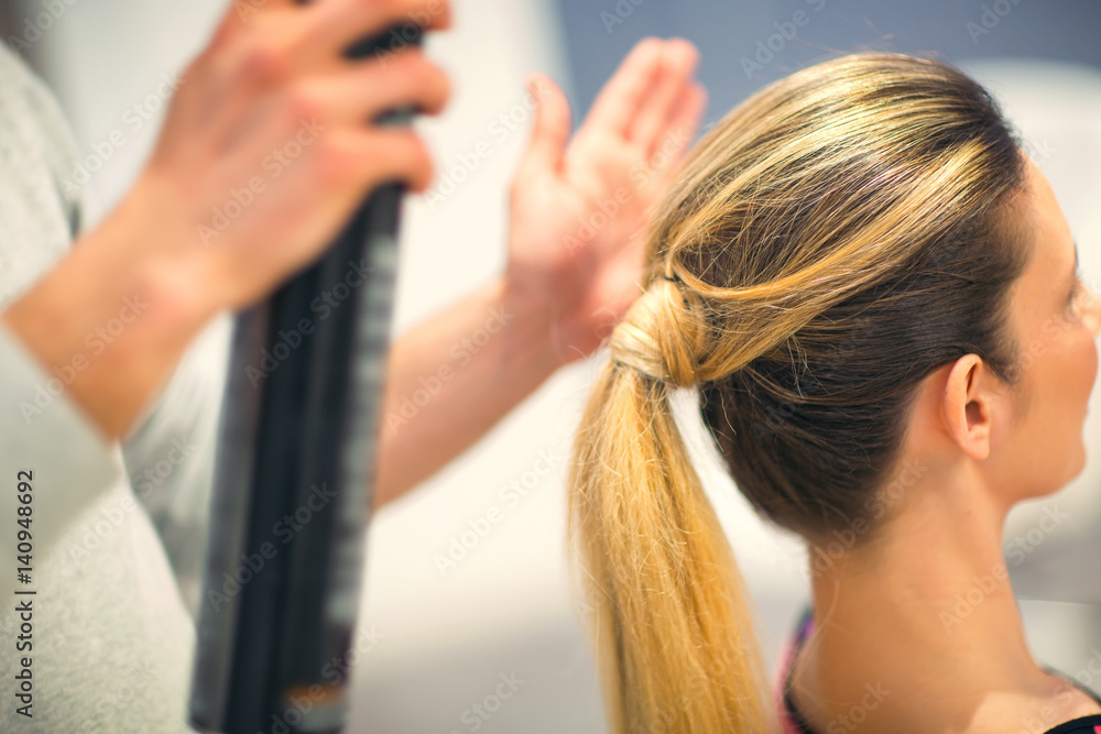 Fototapeta premium Young woman with blonde hair made by hair stylist in beauty salon