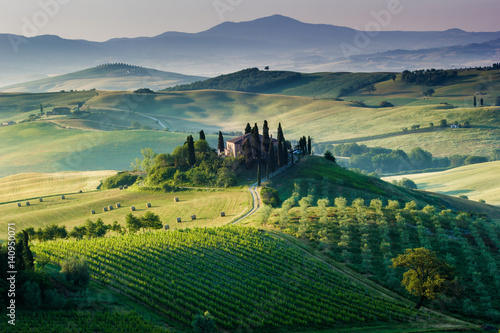 Tuscany, Italy. A beautiful and lonely farmhouse surrounded by green hills of Val d'Orcia photo