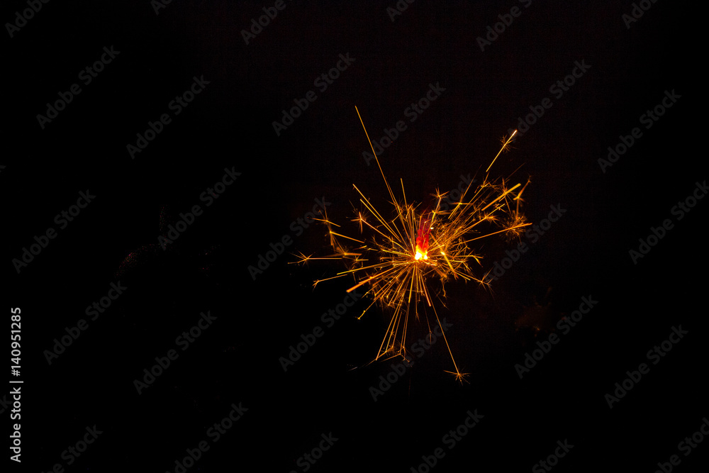 sparkler lit on black background
