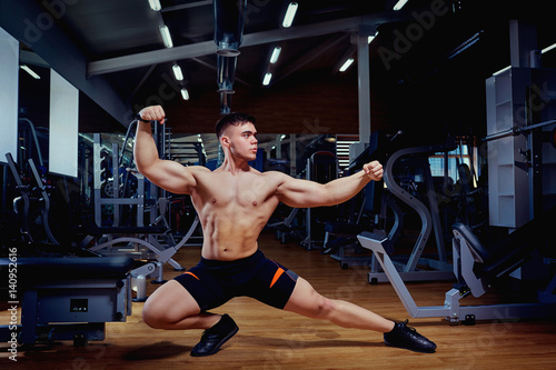 Sportsman athlete bodybuilder posing in the gym.
