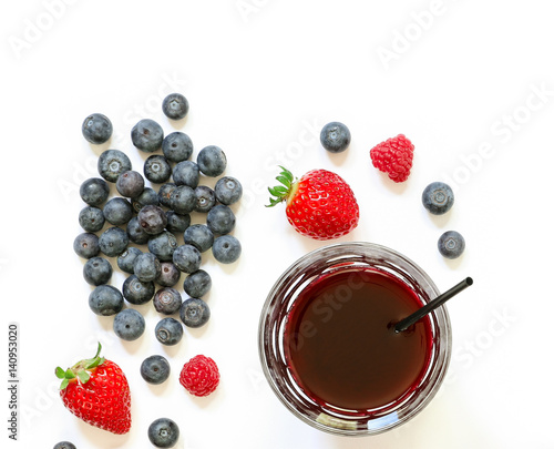 A glass of strawberries, raspberries, blueberries juice isolated on white.