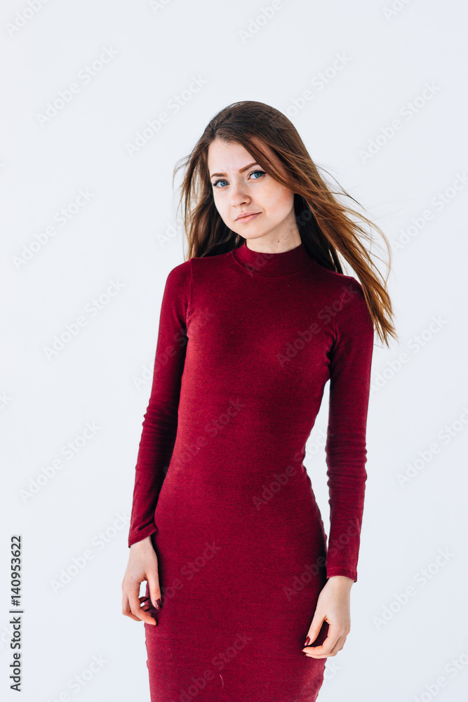 Portrait of a cute young girl on white isolated background in a red tight dress Portrait of a cute young girl on white isolated background in a red tight dress