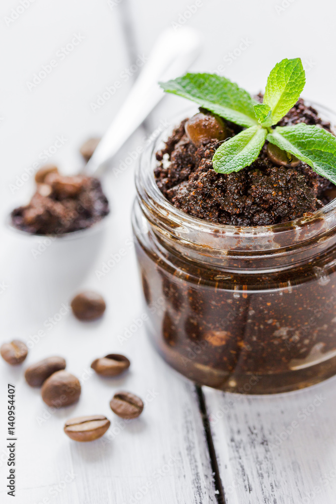 Homemade cosmetics with scrub and coffee beans on desk background Homemade cosmetics with scrub and coffee beans on desk background